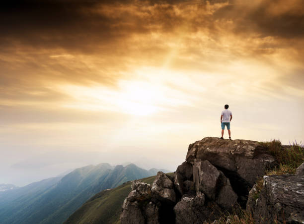 istock Man standing on the top of mountain at sunset 1124647438