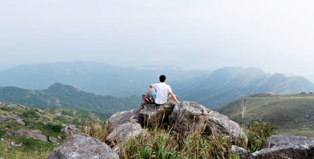 istock Man sitting on the top of mountain 1124647516