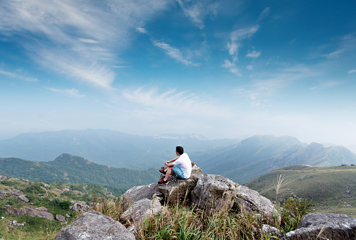 Man sitting on the top of mountain.