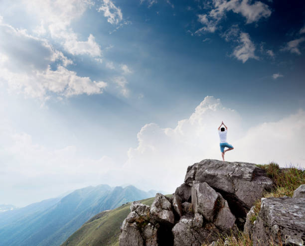 istock Man doing yoga on top of mountain 1124647648