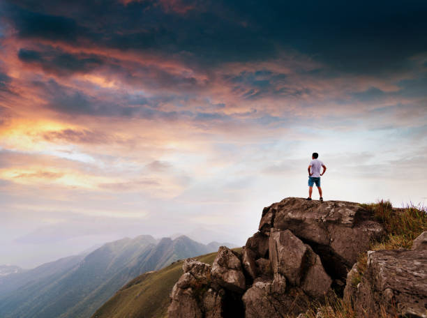 istock Man standing on the top of mountain at sunset 1124647649