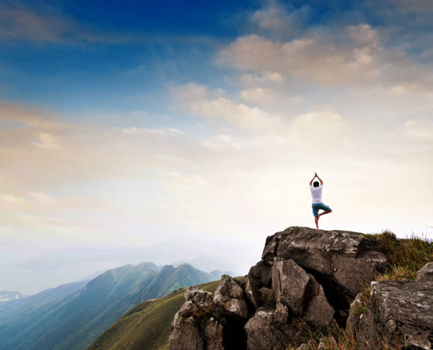 istock Man doing yoga on top of mountain 1124647655