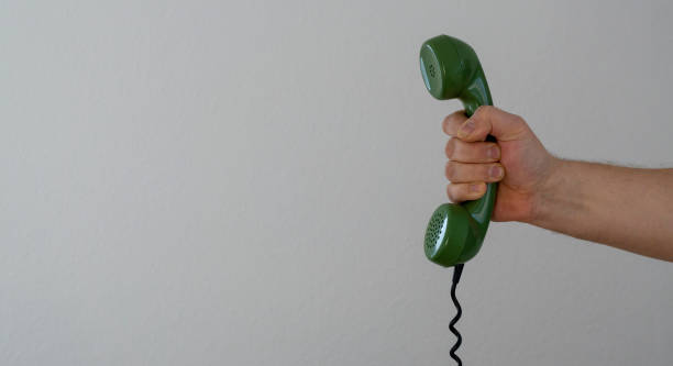 istock hand holding green telephone receiver with copy space, banner size 1124647663