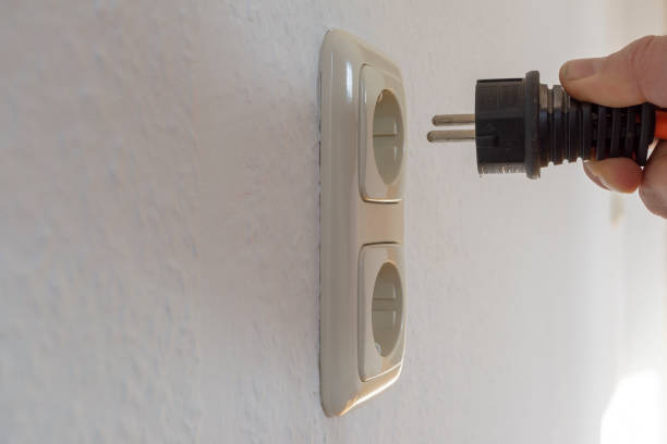 istock Male hand puts plug in the socket 1124647960