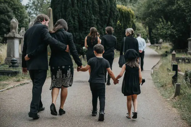 Photo of Grieving family walking through a cemetery