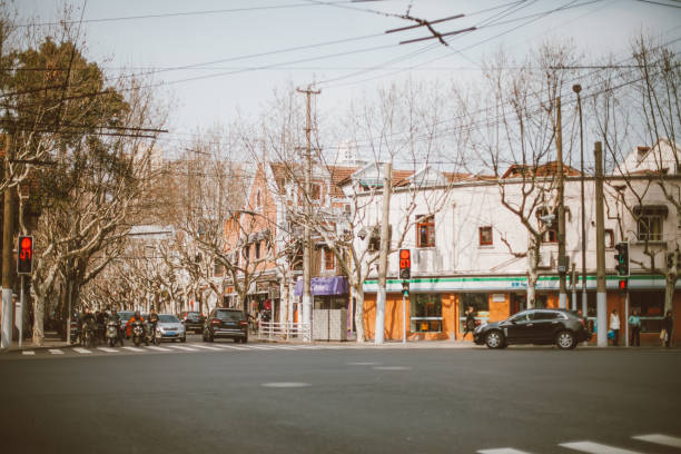 Shanghai, China - March 7th 2015:Picture of People cycling and walking at street in Shanghai. The traditional buildings of Shanghai can be seen in the picture. Shanghai is one of the most busiest and popular cities in the world.