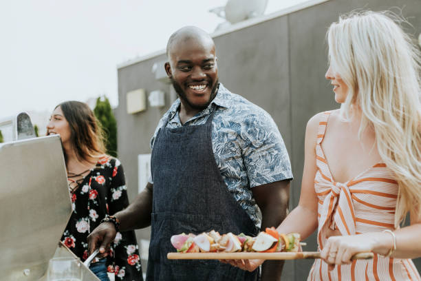 istock Friends grilling barbeque skewers at a rooftop party 1124655263
