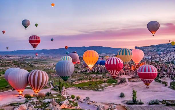 在土耳其卡帕多西亞的戈雷梅國家公園發射前使用五顏六色的熱氣球 - 土耳其 個照片及圖片檔