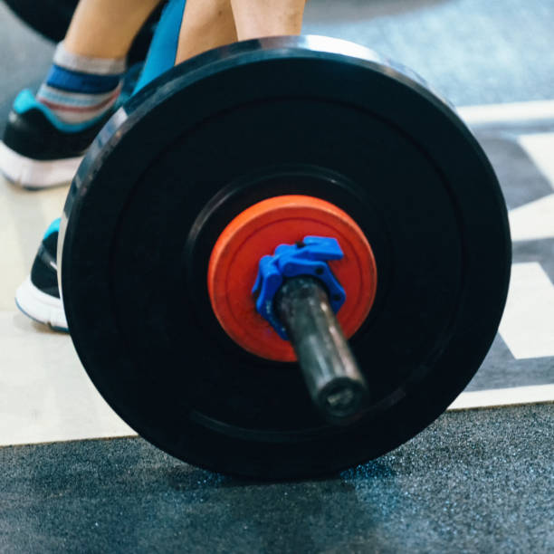 istock Low Section Of Man Holding Barbell In Gym 1124658197