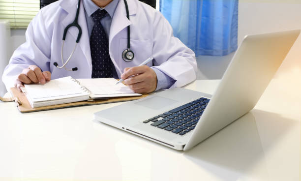 istock Midsection Of Doctor Using Laptop On Table 1124658304