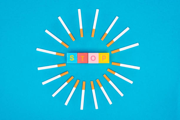 istock Flat lay with cigarettes and colorful letter blocks isolated on blue, stop smoking concept 1124664041