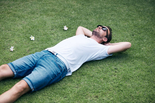 A Boy and a Girl Sleep Lying on a Green Lawn in the Italian Alps during Spring. Roncola, Bergamo Province, Italy