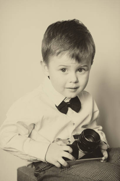 Little boy with aged retro camera. Child with an old camera
