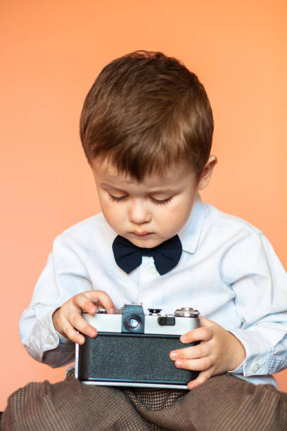 istock Little boy with aged retro camera. Child with an old camera 1124665053