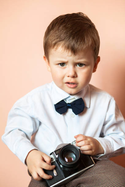 istock Little boy with aged retro camera. Child with an old camera 1124665054