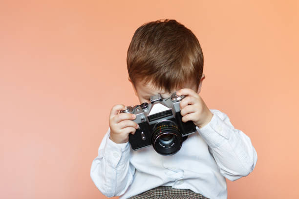 little boy with aged retro camera. child with an old camera - bellow camera photography photography themes photographer imagens e fotografias de stock