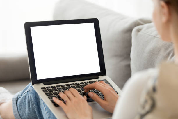 istock Woman using laptop with blank mockup screen at home 1124667616