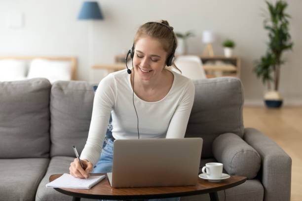 happy girl interprete in cuffia scrivere note studio su laptop - business seminar writing women foto e immagini stock