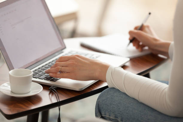 Woman student making notes studying learning online with computer Woman student making notes studying learning online with computer, businesswoman freelancer editor writer working on laptop, female hands writing down information essay from internet close up view quiz time stock pictures, royalty-free photos & images