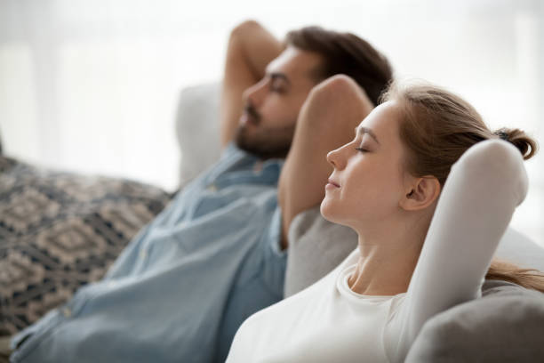 istock Happy calm couple enjoying relaxation having nap on sofa breathing 1124667802