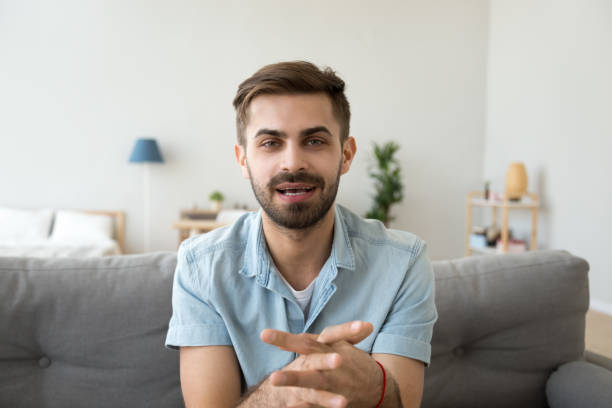 istock Young guy speaking recording vlog at home looking at camera 1124667836