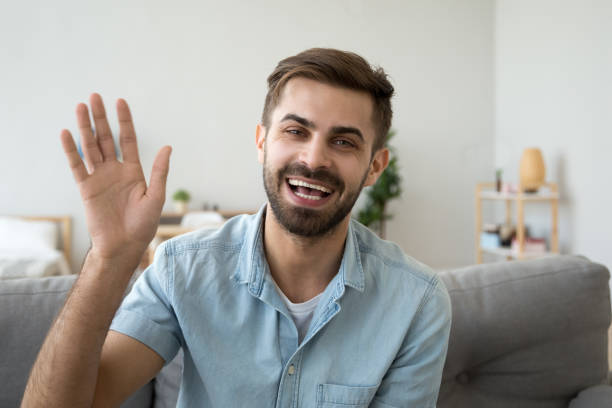 istock Friendly happy man waving hand saying hello looking at camera 1124667876
