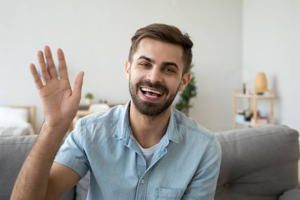 amigável homem feliz, acenando a mão dizendo olá olhando para a câmera - romantic activity audio - fotografias e filmes do acervo