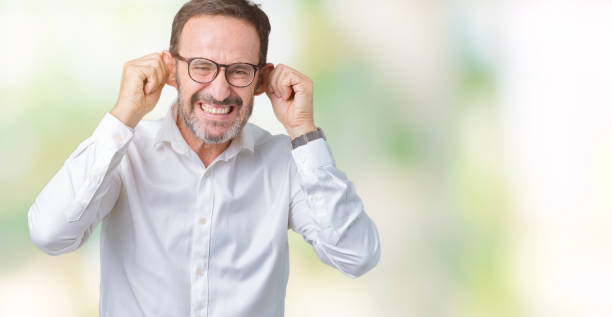 beau moyen âge élégant homme d'affaires aîné portant des lunettes sur le fond isolé souriant tirant les oreilles avec les doigts, geste drôle. problème d'audition - casting glass photos et images de collection