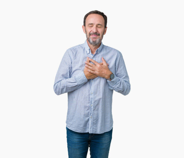 istock Handsome middle age elegant senior man over isolated background smiling with hands on chest with closed eyes and grateful gesture on face. Health concept. 1124668108