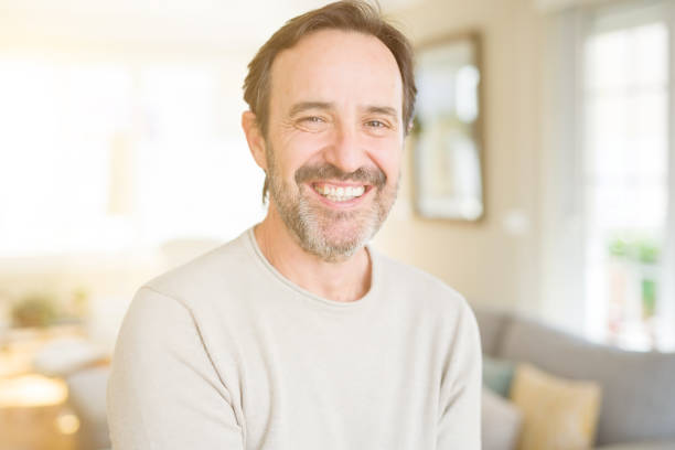 istock Handsome middle age man smiling looking at the camera at home 1124669160