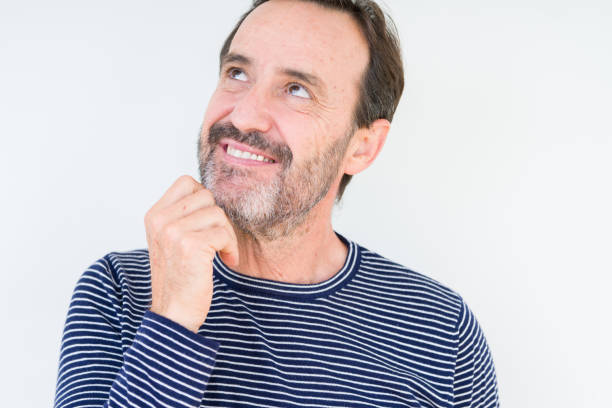 istock Handsome senior man over isolated background with hand on chin thinking about question, pensive expression. Smiling with thoughtful face. Doubt concept. 1124670258