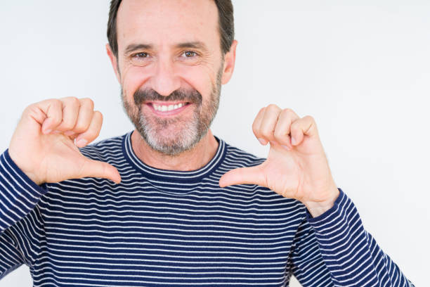 istock Handsome senior man over isolated background looking confident with smile on face, pointing oneself with fingers proud and happy. 1124670517