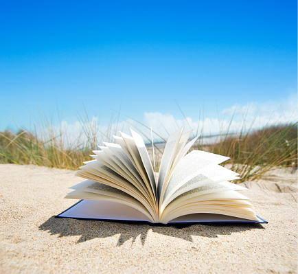 Opened book in the sand
