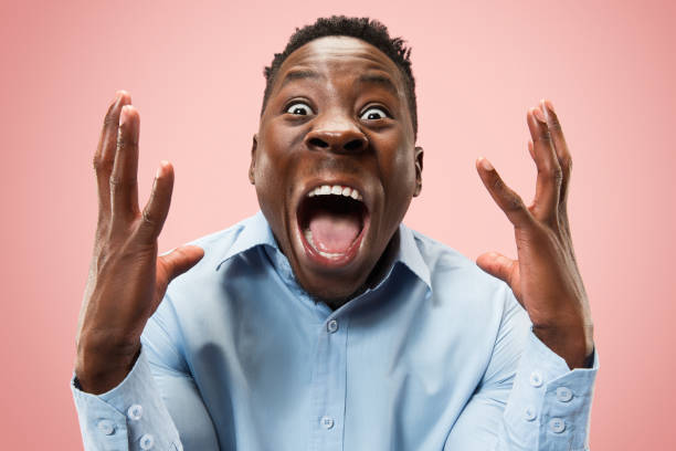 istock The young attractive man looking suprised isolated on pink 1124671028