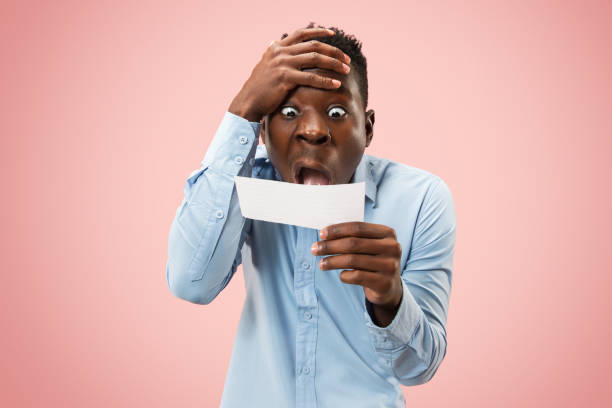 istock Young boy with a surprised expression bet slip on pink background 1124671039