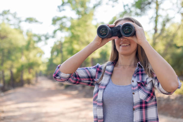 istock Young female traveler looking with binoculars 1124671620