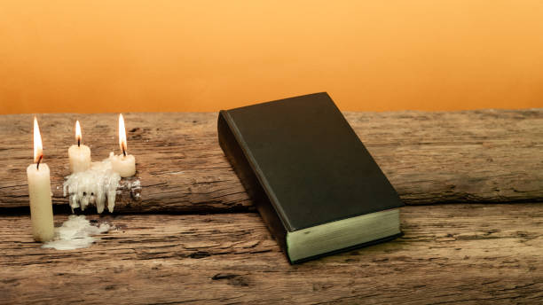 istock Closed Holy Bible and candle on a old oak wooden table. 1124673145