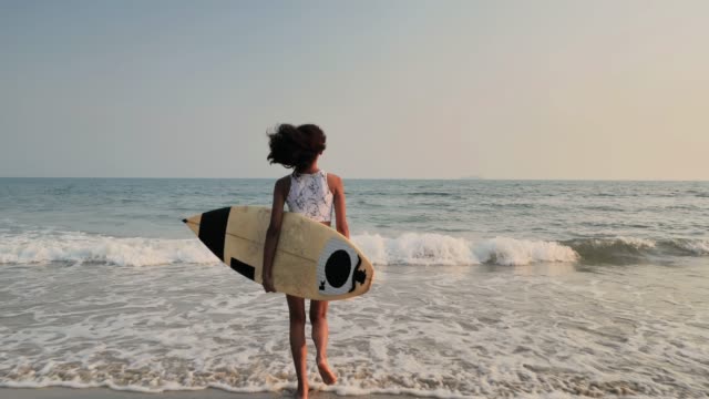 Sports Cinemagraphs :Beautiful sexy surfer girl on the beach at sunset