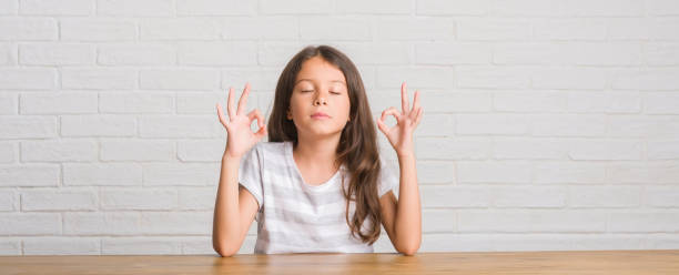 istock Young hispanic kid sitting on the table at home relax and smiling with eyes closed doing meditation gesture with fingers. Yoga concept. 1124675592