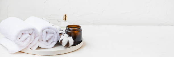 istock Spa still life setting with white cotton buds and towels, scented candle and perfume bottle, minimal interior still life and decor 1124677757