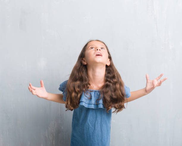 istock Young hispanic kid over grunge grey wall crazy and mad shouting and yelling with aggressive expression and arms raised. Frustration concept. 1124678177
