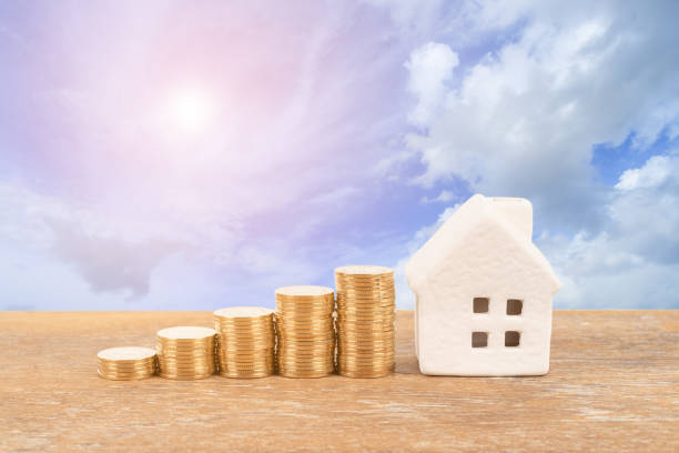 istock Model house and coin stack on blue sky background mortgage saving concept 1124680582