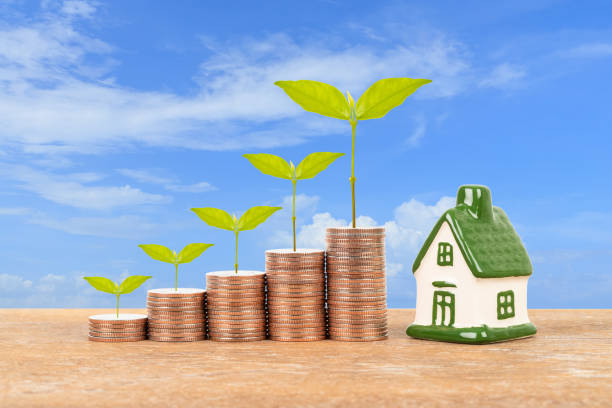 istock Model house and coin stack with tree on blue sky background mortgage saving concept 1124680605