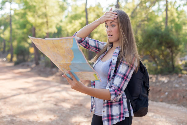 молодая женщина cheking карту в лесу - discovery forest lost confusion стоковые фото и изображения