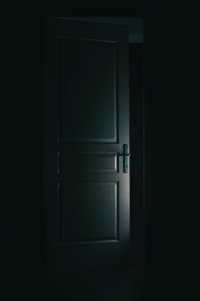 часть двери, освещенной в темноте - curiosity searching discovery home interior стоковые фото и изображения