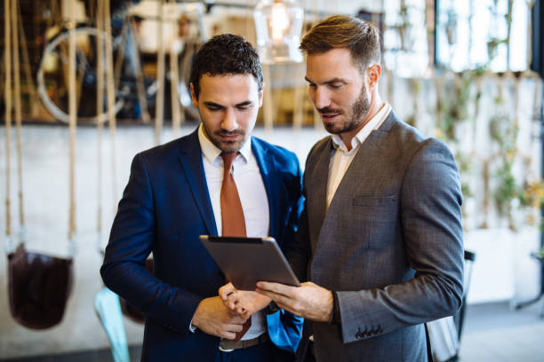istock Two young businessmen discussing business strategy using digital tablet 1124685715
