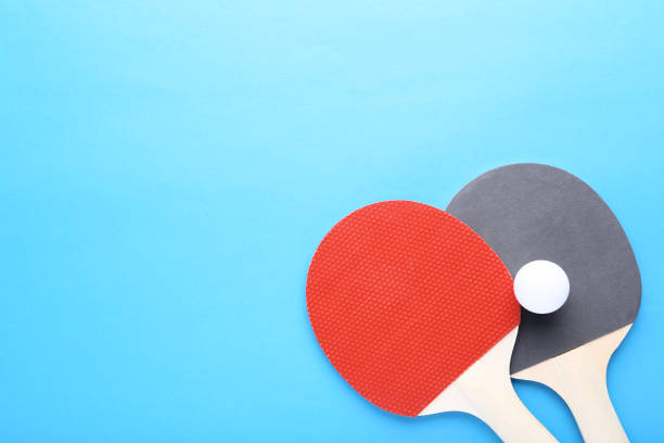 istock Table tennis rackets with ball on blue background 1124686338