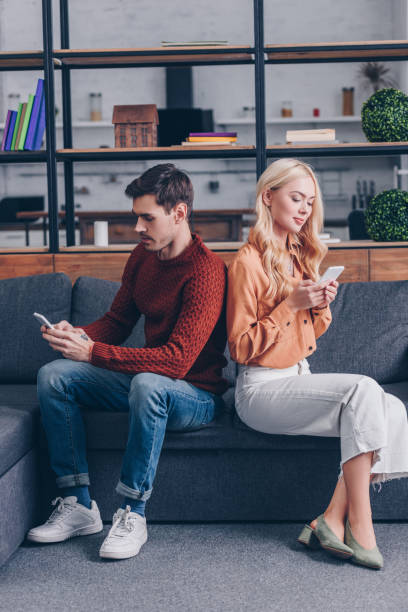 istock young couple sitting back to back and using smartphones, relationship problem concept 1124687792