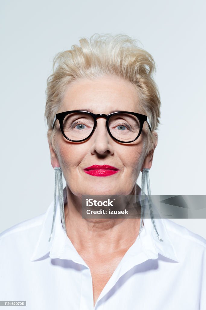 Portrait of elegant elderly lady Glamour portrait of beautiful confident senior woman wearing white shirt and glasses, smiling at camera. Senior Women Stock Photo
