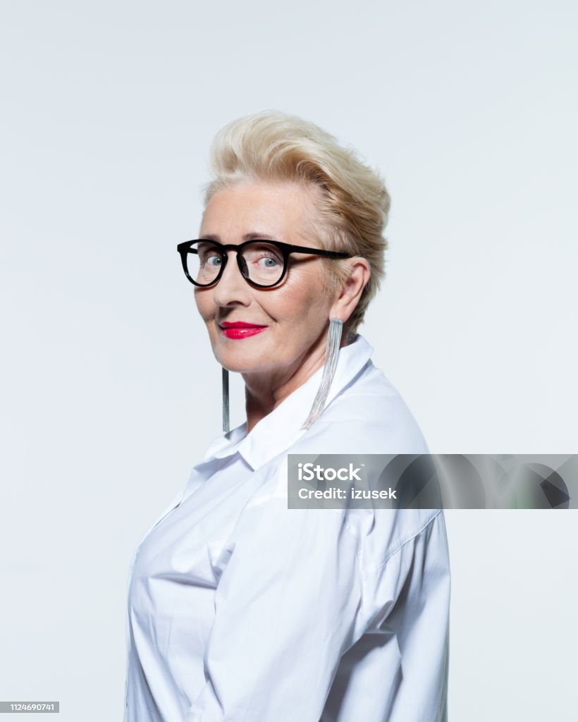 Portrait of elegant elderly lady Glamour portrait of beautiful confident senior woman wearing white shirt and glasses, smiling at camera. 60-69 Years Stock Photo